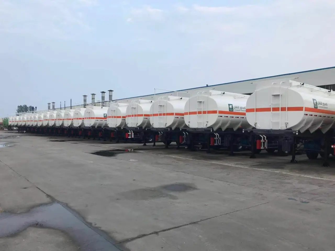 Row of white fuel tanker trailers ready for delivery
