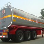 Rear three-quarter view of a silver tanker on a red chassis