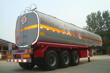 Rear three-quarter view of a silver tanker on a red chassis