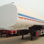 White tanker trailer with blue and red stripes viewed from the front
