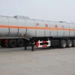 Side view of a silver tanker with three rear axles