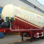 White and red powder tanker with front-mounted equipment