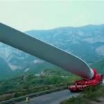 Wind-turbine blade on a trailer along a mountain road