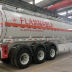 Silver tanker marked Flammable inside a workshop