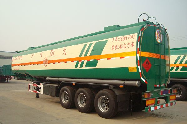 Rear three-quarter view of a green tanker trailer