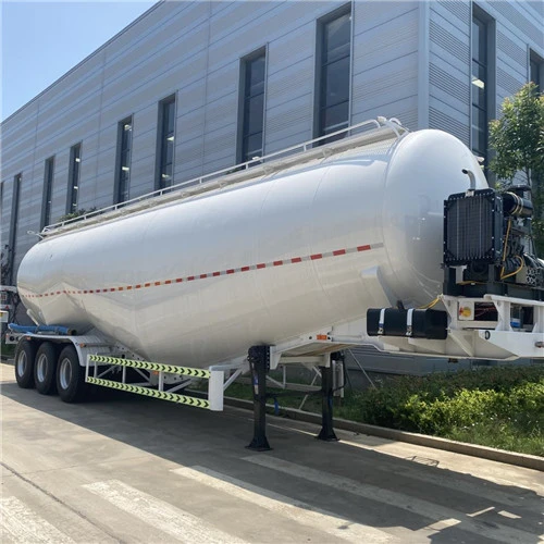 White powder tanker parked beside a workshop