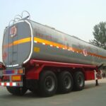 Rear three-quarter view of a silver tanker on a red chassis