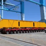 Modular heavy-haul trailer carrying a large yellow structure