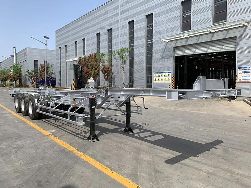 2 Unpainted skeletal trailer frames outside a workshop