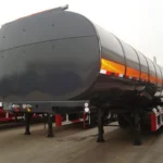 Front three-quarter view of a dark tanker trailer