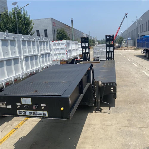 Dark lowbed trailer with rear loading ramps
